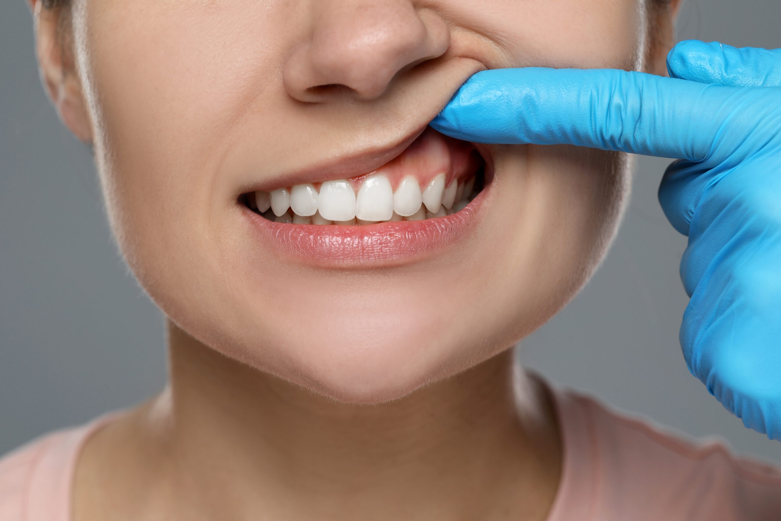 dentist examines patients gum for signs of gum disease