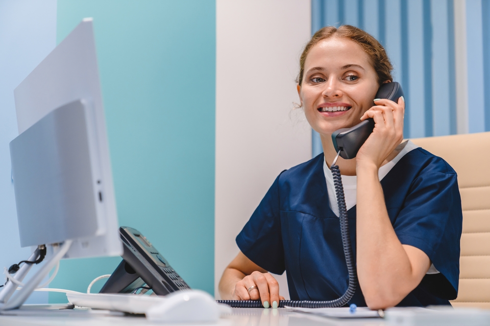 shutterstock 2385184461 woman answering phone at dentist