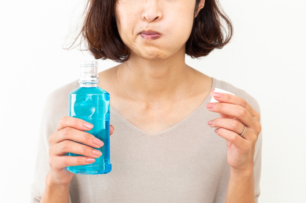 woman using mouthwash