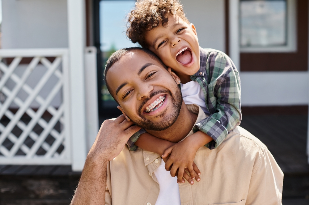 Positive,African,American,Boy,Hugging,Excited,Father,In,Braces,On father who wears braces smiling with child