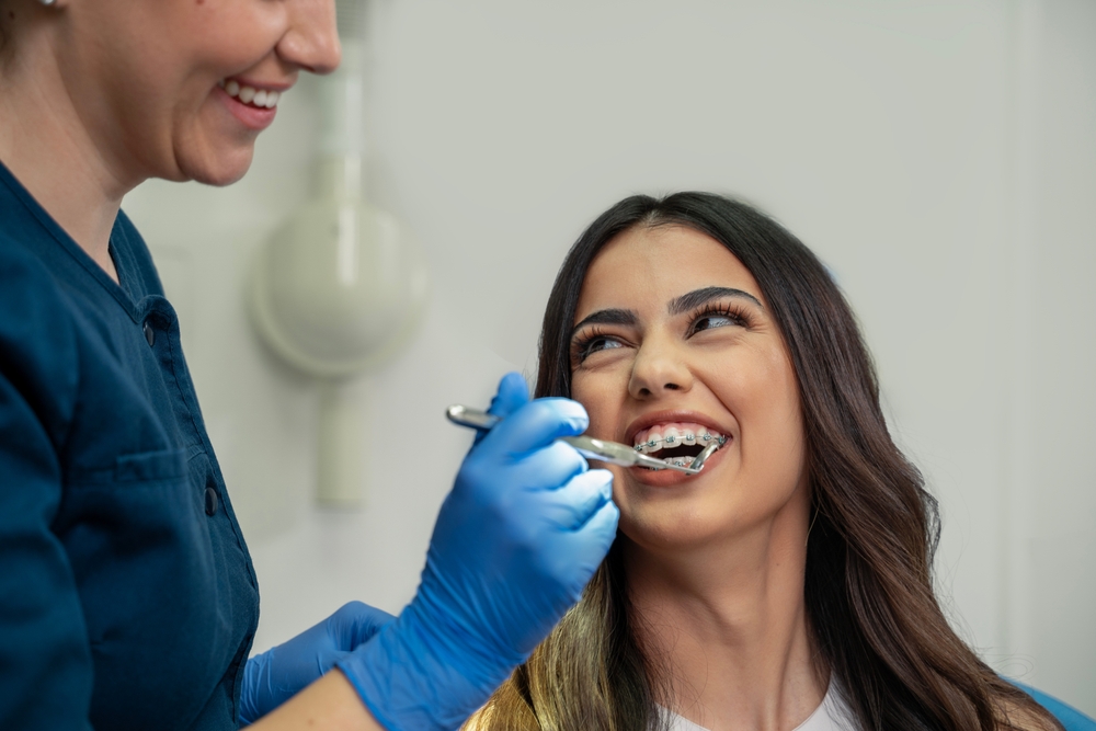woman with braces getting a checkup at the dentist