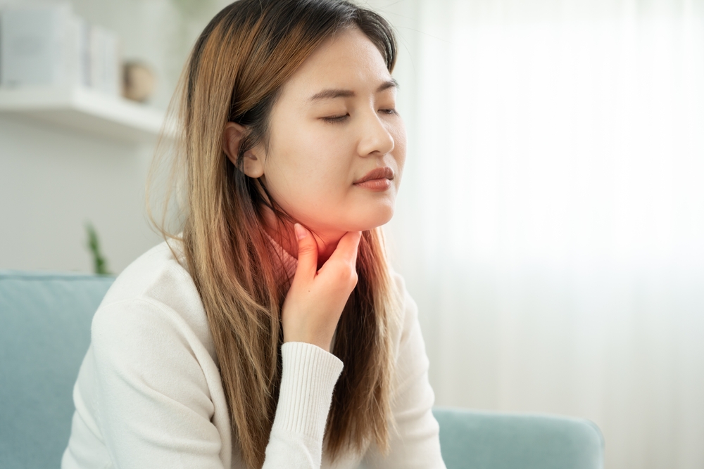 Asian,Woman,Put,Her,Hand,On,Her,Neck,Due,To