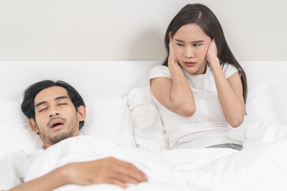 couple struggles to sleep due to snoring/sleep apnea