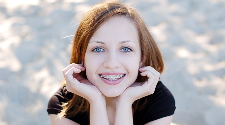 Teenage girl with braces smiling.